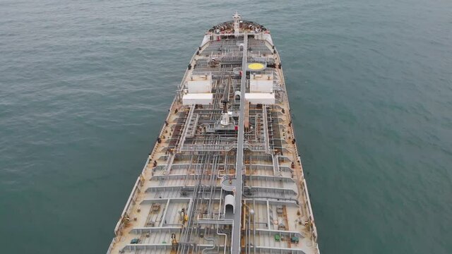 Low flight above the deck of an oil tanker at anchor.