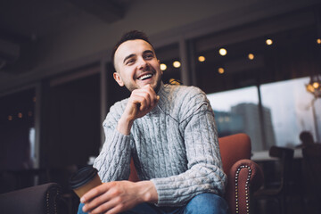 Cheerful man drinking coffee and smiling
