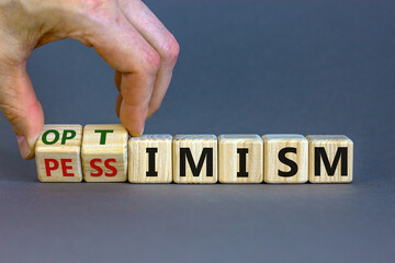 Male hand turns cubes and changes the expression 'pessimism' to 'optimism'. Beautiful grey...