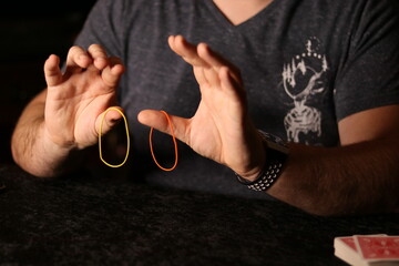 close up of a magician practicing a rubberband trick