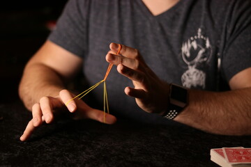 close up of a magician practicing a rubberband trick