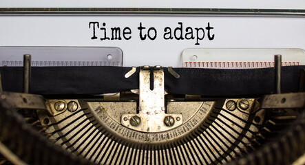 Text 'time to adapt' typed on retro typewriter. Business concept.
