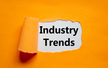 The words 'industry trends' appearing behind torn orange paper. Business concept. Copy space.