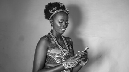 Black & White portrait of young happy Nigerian woman using her phone