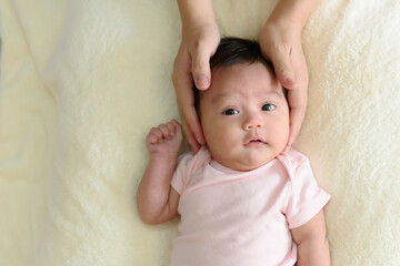 Top view of hand holding head of cute little Asian baby girl