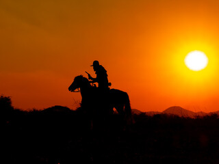 The Western Cowboy forced his horses to stop while the sun was setting, In lands where the law has not yet reached