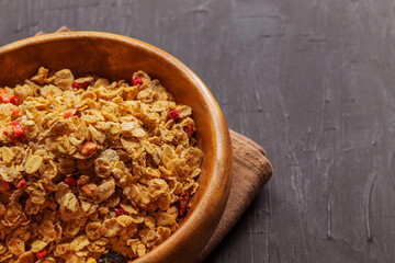 Multi-glale muesli with berries lie in a wooden bowl