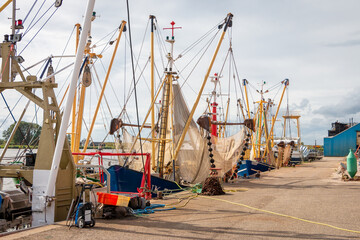 Fishing boats with shrimps on the river Reitdiep and Zoutkamperril in the harbor of Zoutkamp on a summer day with blue sky and white clouds