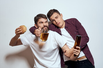 Two cheerful friends drinking beer drunk fun lifestyle communication light background