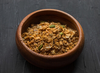 Multi-glier muesli with flax and pumpkin seeds lie in a wooden plate