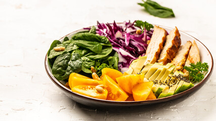 Plate with a keto diet food with chicken fillet, purple cabbage, avocado, spinach, tomatoes and nuts. Detox and healthy concept. Keto paleo lunch