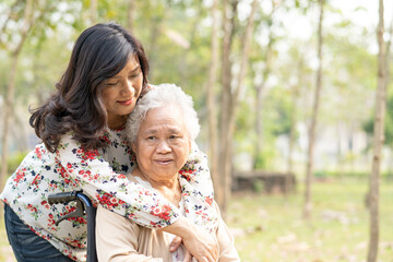 Asian senior or elderly old lady woman patient with care, help and support on wheelchair in park in...