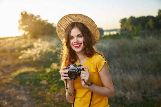 Woman photographer camera in hands smile red lips hat attractive look nature