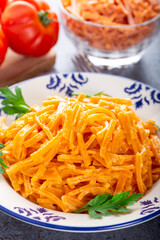 Red colored homemade traditional tomato pasta or noodles.