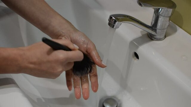 Woman Washes Makeup Brushes With Tap Water In The Sink