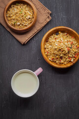 Berry and muesli seeds with flax and pumpkin seeds, as well as milk in a mug on a black background