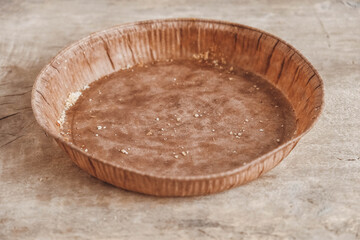Paper craft plate with crumbs on vintage wooden background texture. Copy, empty space for text