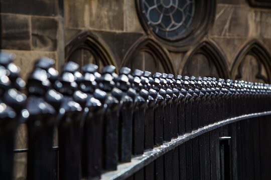Detail of wrought iron fence with facade ornaments in the background