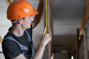 male builder dressed in work clothes and an orange hard hat