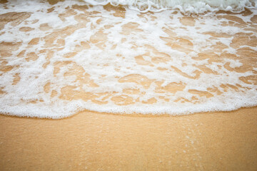 The waves hit a beautiful beach on one of the islands of Thailand.
