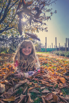 beautiful blond girl lying in colorful autumnal foliage