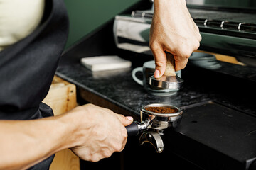 Woman coffee shop worker preparing coffee on professional coffee machine
