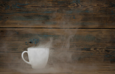 hot coffee cup and smoke on wooden dark background