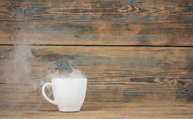 Fototapeta na wymiar hot coffee cup and smoke on wooden dark background
