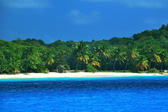 malownicza karaibska wysepka Petit Saint Vincent w lutym. Widok od strony morza. Biały piasek, błękitna woda dużo zieleni