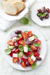 Simple salad with cherry tomatoes, feta cheese, kalamata olives, red pepper and fresh herbs. Bright...