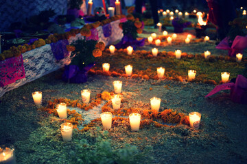 candles over flowers at day of the dead memorial