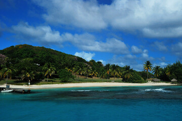 Fototapeta na wymiar malownicza karaibska wysepka Petit Saint Vincent w lutym. Widok od strony morza. Biały piasek, błękitna woda dużo zieleni