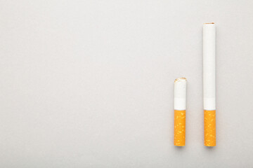 Cigarette butt with cigarette on grey background.