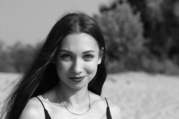 Black and  white portrait of long-haired young brunette woman outside