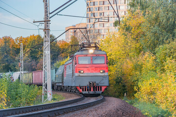 Freight train moves at autumn evening time.