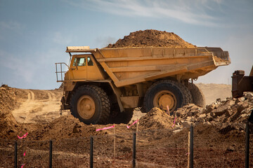 A very large haul dump truck filled with dirt at a construction site