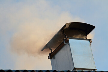 Fototapeta na wymiar Smoke puffing out of a chimney