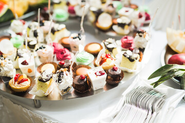 Delicious and tasty dessert table with cupcakes shots at reception closeup