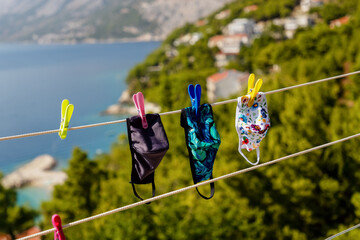 Fabric masks hanging on the clothesline on the sea background. Coronavirus concept.