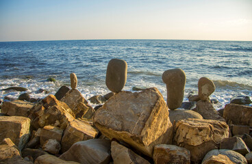 Balanced stones on the seashore summertime and sea background
