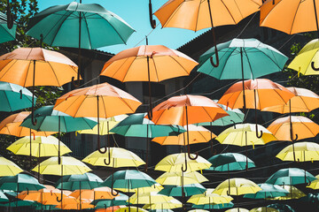 Colorful umbrellas hung across the street creating a pattern