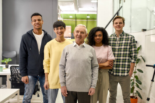 Happy diverse team of employees looking at camera while posing, standing together in the office, Age diversity in the workplace