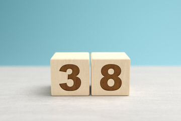 Wooden toy blocks forming the number 38.
