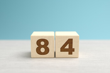 Wooden toy blocks forming the number 84.