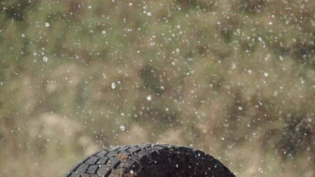 Explosion of a water bottle from a bullet shot. Splash and water droplets down in slow motion. 