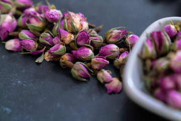Large variety of multi colored dried tea leaves and flowers shot on white table