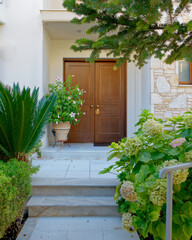 family house front entrance natural wood door and garden