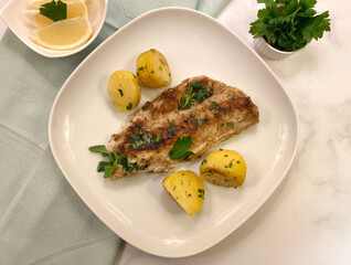 Pike Perch Zander fish fillet  from grill with parsley potatoes.