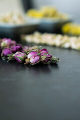 Large variety of multi colored dried tea leaves and flowers shot on white table