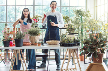 Young couple gardening plants together at home